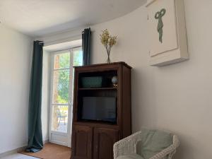 a living room with a tv and a entertainment center at Orchid Cottage in Gorges