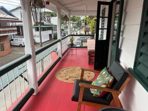 a porch with a chair and a rug on it at Coffee Mama Stay in Paramaribo