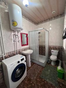 a bathroom with a washing machine and a toilet at Fazenda guest house in Oktyabrʼskoye +25 photos