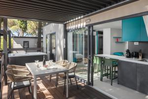 an open kitchen and dining room with a table and chairs at Boutique Camping Materada Beach in Poreč