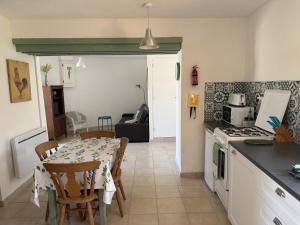 a kitchen with a table and a kitchen with a table and chairs at Orchid Cottage in Gorges