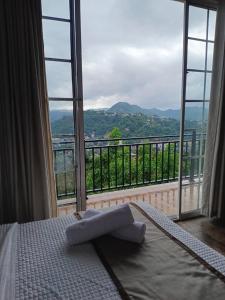 a bedroom with a bed and a large window at Sentinels Hotel Kandy in Kandy