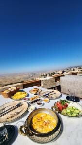ein Tisch mit Tellern voller Essen und Aussicht in der Unterkunft Kadim Hotel in Mardin