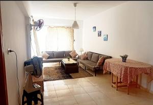 a living room with a couch and a table at Full board rent in Ras Sedr