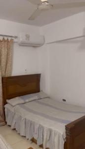 a bed in a room with a white wall at Full board rent in Ras Sedr