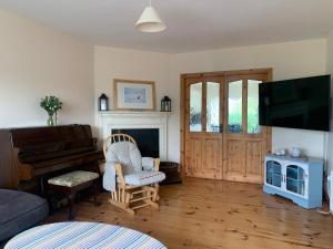 a living room with a piano and a chair at Atlantic Holiday Home in Milltown Malbay