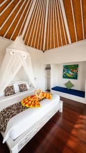 a white bed with pillows on it in a room at Tawe Ocean Blue Villa Lembongan in Nusa Lembongan