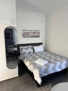 a bedroom with a bed with a mirror and a table at Muzo Guest Nest in Cape Town