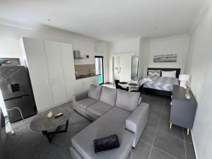 a living room with a couch and a bed at Muzo Guest Nest in Cape Town