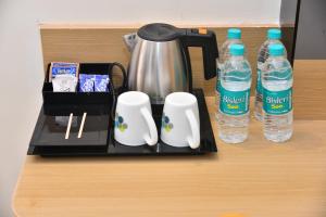 a coffee maker and two bottles of water on a counter at Vels Grand Hotel in Kanchipuram