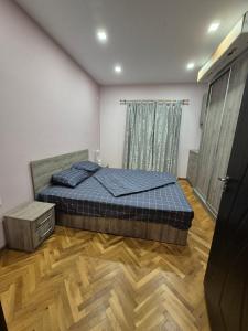 a bedroom with a bed and a wooden floor at Апартамент riverside in Yambol +3 photos