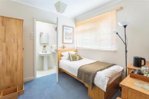a bedroom with a bed and a sink in it at Avoncourt Lodge in Ilfracombe +14 photos