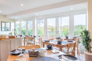 a dining room with tables and chairs and windows at Avoncourt Lodge in Ilfracombe