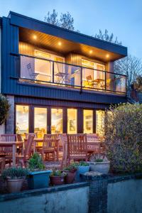 a house with a balcony with chairs and a table at Avoncourt Lodge in Ilfracombe