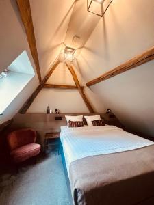 een zolderkamer met een bed en een stoel bij Hotel de Prince in Nijmegen +230 foto's