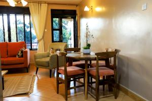 a dining room with a table and chairs in a room at Kingram Apartments in Entebbe