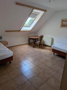 a attic room with a table and a window at Adlerhorst in Bruchhausen-Vilsen