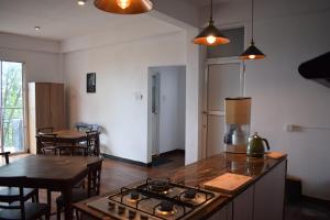 a kitchen with a stove and a table with chairs at Sentinels Hotel Kandy in Kandy
