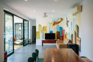 a living room with a large mural of buildings on the wall at Daisy Queen Village Ba Vì in Yên Cư