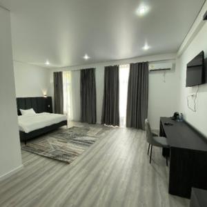 a hotel room with a bed and a desk and a desk at TUMAR hotel in Zhezdi
