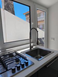 a kitchen with a sink and a stove and a window at La Terrazza dell'Abate in Maiori +7 photos