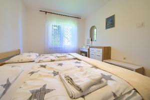 a bedroom with a bed with towels on it at Apartments Jurina in Krk