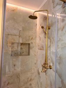 a shower with a glass door in a bathroom at Guesthouse Bârlogul Balaurului in Afumaţi