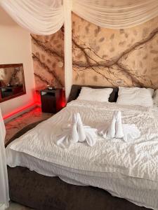 a bedroom with a white bed with white sheets at Guesthouse Bârlogul Balaurului in Afumaţi