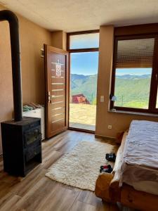 a bedroom with a fireplace and a bed and a window at Hotel Te Liqeni in Peje