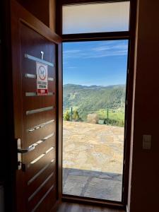 a door with a view of a field through a window at Hotel Te Liqeni in Peje