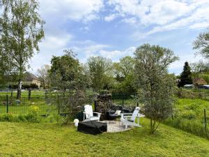 a yard with two white chairs and a fence at Haus Güldengossa in Großpösna
