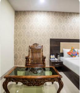 a living room with a coffee table and a bed at Hotel Tirumala in Secunderabad