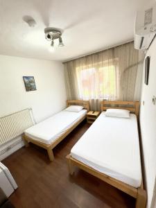 a room with two beds and a window at Pensiunea Pitaru in Calafat
