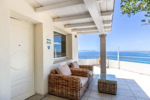 a porch with wicker chairs and a view of the ocean at Villa La Gioia in Terra Mala