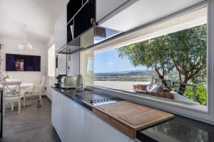 a kitchen with a large window and a counter with a table at Villa La Gioia in Terra Mala