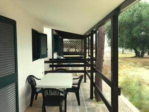 a patio with a table and chairs on a balcony at Camping Porto Miggiano in Santa Cesarea Terme