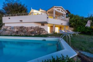 a villa with a swimming pool in front of a house at Villa La Gioia in Terra Mala