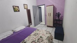 a bedroom with a bed with a purple bedspread at Nomah Hostel in Sao Jose do Rio Preto