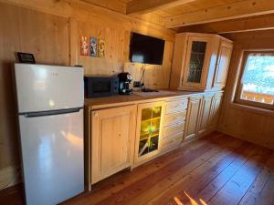 a kitchen with a white refrigerator in a cabin at Ceda Fiore in Costalta +10 photos