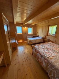 a bedroom with two beds in a wooden cabin at Ceda Fiore in Costalta