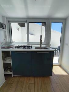 a kitchen with a sink and two windows at La Terrazza dell'Abate in Maiori