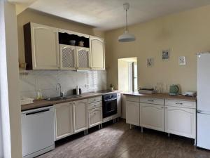 a kitchen with white cabinets and a refrigerator at Kuća za odmor Belvedere in Siverić