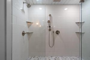 a bathroom with a shower with a glass door at Downtown Fairhope Cottage in Fairhope +12 photos