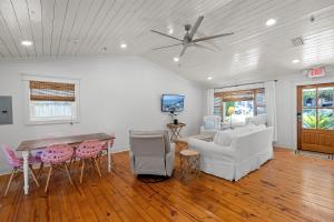 a living room with a ceiling fan and a table and chairs at Downtown Fairhope Cottage in Fairhope