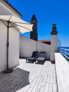 a patio with two chairs and an umbrella at La Terrazza dell'Abate in Maiori