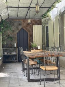 a wooden table and chairs on a patio at Le Patio Des Senteurs in Verzeille