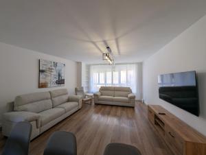 a living room with a couch and a flat screen tv at Alojamientos Bahia de Santoña 4 in Santoña
