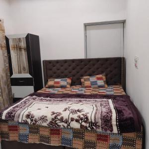 a bedroom with a bed with a blanket and pillows at Atlas blue hotel in Bathinda