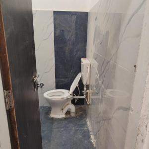 a bathroom with a white toilet in a stall at Atlas blue hotel in Bathinda