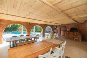 a living room with wooden ceilings and tables and chairs at The Valley Escape - Executive Suite in Gqeberha